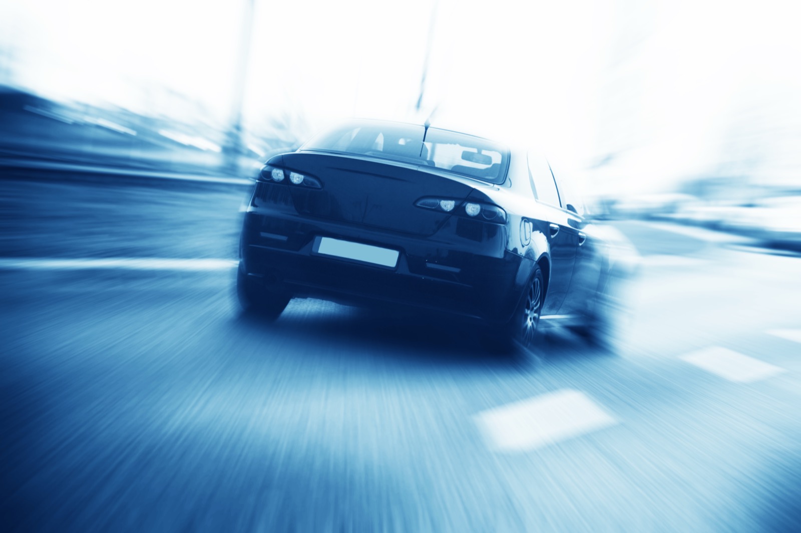 voiture s'éloignant à vive allure sur la route